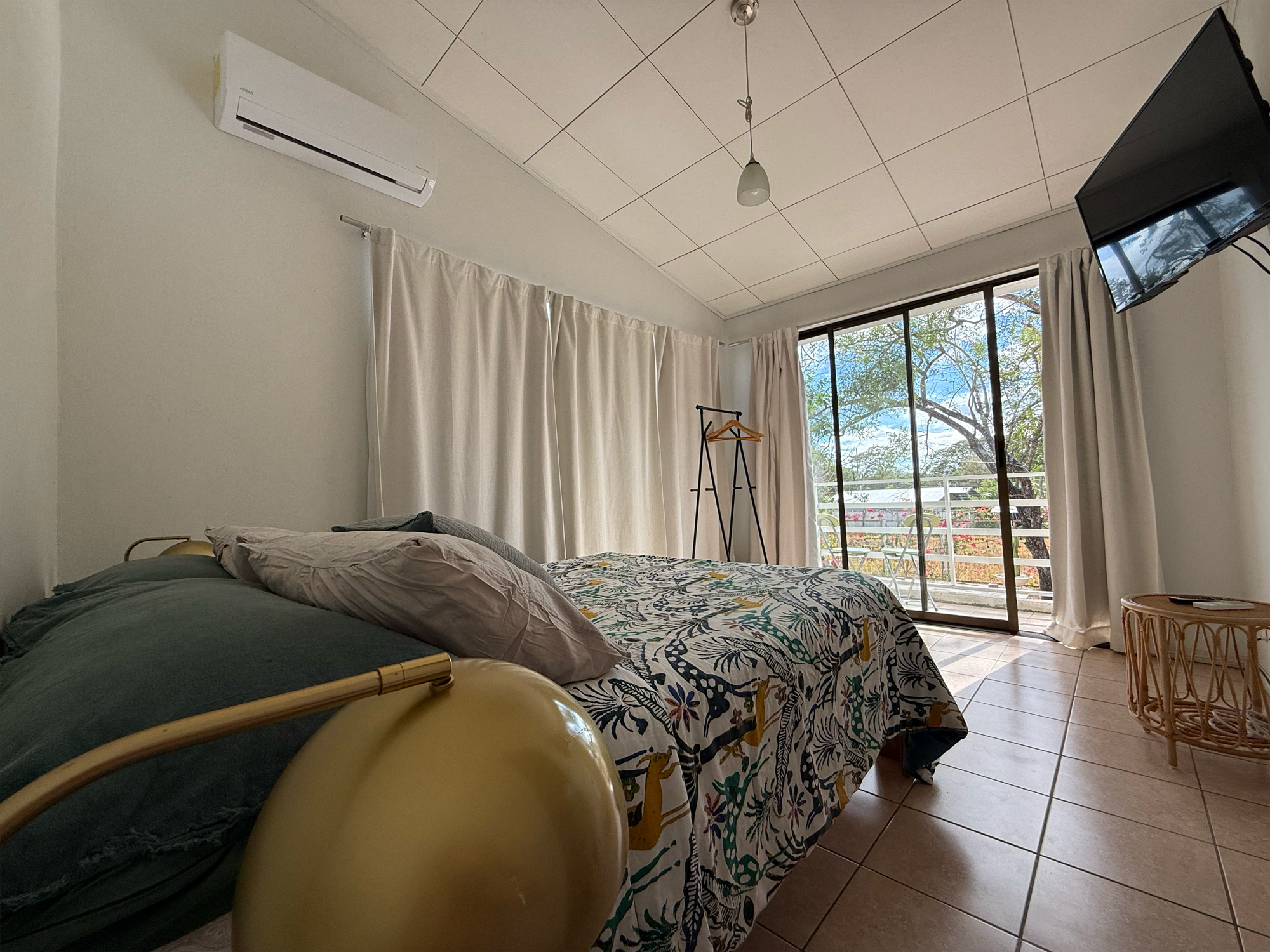 Habitación con balcón hacia el jardín en Casa Buda Liberia