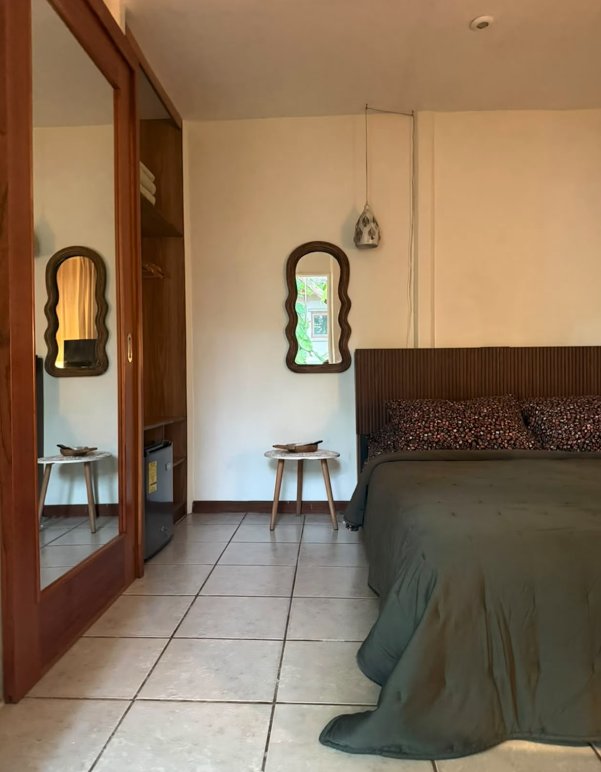 Buda Garden Room en Casa Buda Liberia, habitación con cama verde y espejos de madera